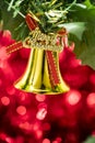 Christmas bell ornament hang on tree branch with red bokeh background Royalty Free Stock Photo