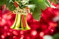 Christmas bell ornament hang on tree branch with red bokeh background Royalty Free Stock Photo