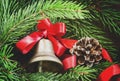 Christmas bell with a red ribbon, pine-needles and cones on old Royalty Free Stock Photo