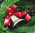 Christmas bell with a red ribbon, pine-needles and cones on old Royalty Free Stock Photo