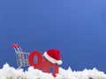 Christmas big sales: shopping cart with Santa hat and symbol of percent on wooden background over dark blue wall Royalty Free Stock Photo