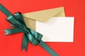 Christmas or birthday card on red gift wrap paper background, green gift ribbon bow, white copy space Royalty Free Stock Photo