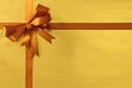 Christmas or birthday gift bow ribbon, background gold metallic foil, copy space