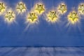 Christmas blank interior with glow lights yellow stars on indigo blue wood background.