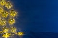 Christmas blank interior with glow lights yellow stars on indigo blue wood background.