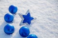 Christmas blue ball and star in the snow on a sunny day Royalty Free Stock Photo