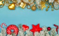 Christmas border. Blue Xmas background with red holly berries, gold garland, winter holiday decor and green fir branch Royalty Free Stock Photo