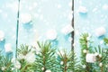 Christmas border with branch of fir tree and marshmallows on wooden background decorated with snow