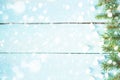 Christmas border with branch of fir tree and marshmallows on wooden background decorated with snow