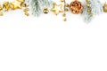 Christmas border composition. Gold decorations and green fir branch on white background. Xmas flat lay top view