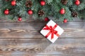 Christmas border with fir branches, red balls, cones and gift on a wooden background Royalty Free Stock Photo