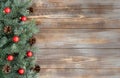 Christmas border with fir branches, red balls and cones on a wooden background Royalty Free Stock Photo