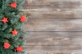 Christmas border. Fir branches and red festive decorations, stars and hearts on a wooden background. Happy new year. Copy space, Royalty Free Stock Photo