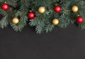 Christmas border with fir branches, red and gold balls on a black background Royalty Free Stock Photo