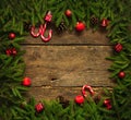 Christmas border with fir tree branches, cones, christmas decorations and candy cane on rustic wooden boards Royalty Free Stock Photo