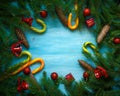 Christmas border with fir tree branches, cones, christmas decorations and candy cane on blue wooden boards Royalty Free Stock Photo