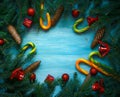 Christmas border with fir tree branches, cones, christmas decorations and candy cane on blue wooden boards Royalty Free Stock Photo