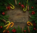 Christmas border with fir tree branches, cones, christmas decorations and candy cane on rustic wooden boards Royalty Free Stock Photo