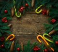 Christmas border with fir tree branches, cones, christmas decorations and candy cane on rustic wooden boards Royalty Free Stock Photo