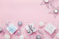 Christmas border with gift boxes, balls, decoration and sequins on pink table top view. Flat lay. Copy space for greeting card. Royalty Free Stock Photo