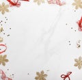 Christmas border frame made of red bows and gold snowflakes of Christmas decorations on a gray marble background. Royalty Free Stock Photo