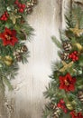 Christmas border with poinsettia, holly and fir branches on a wooden background. Royalty Free Stock Photo