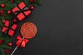 Christmas border with red gifts, lollipop and festive decorations on black background. Xmas greeting card. Happy New Year. View Royalty Free Stock Photo