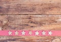 Christmas border with stars ornaments on red ribbon border and rustic wooden background Royalty Free Stock Photo