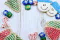 Christmas border of sweets, including cookies, peppermints and chocolates on a rustic wooden background.