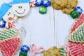 Christmas border of sweets, including cookies, peppermints and chocolates on a rustic wooden background.