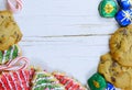 Christmas border of sweets, including cookies, peppermints and chocolates on a rustic wooden background.