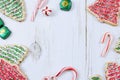 Christmas border of sweets, including cookies, peppermints and chocolates on a rustic wooden background.