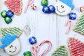 Christmas border of sweets, including cookies, peppermints and chocolates on a rustic wooden background.