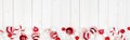 Christmas bottom border banner with red and white ornaments, top view on a white wood background Royalty Free Stock Photo