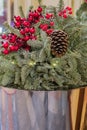 Christmas bouquet composition with tree branches, pine cone and red berries in metal basket Royalty Free Stock Photo