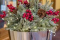 Christmas bouquet composition with tree branches, pine cone and red berries in metal basket Royalty Free Stock Photo