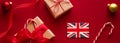 Christmas, boxing day and United Kingdom flag, traditional holiday gifts, presents on red background flat lay, wrapped Royalty Free Stock Photo