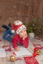 Christmas boy writing letter to Santa Claus. Christmas helper child letter in red hat Royalty Free Stock Photo