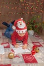 Christmas boy writing letter to Santa Claus. Christmas helper child letter in red hat Royalty Free Stock Photo