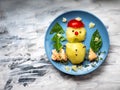 Christmas breakfast for the child. Snowman made of potatoes and green Christmas trees from basil on a blue plate Royalty Free Stock Photo