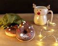 Christmas breakfast table with chocolate donuts decorated red and white sprinkles with hot cocoa in deer mug Royalty Free Stock Photo