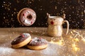 Christmas breakfast table with flying chocolate donut decorated with red and white sprinkles, hot cocoa in deer mug on Royalty Free Stock Photo