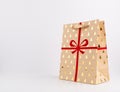 Christmas Brown Paper Bag with Red Ribbon and glittering golden trees on white background, glittering, Royalty Free Stock Photo