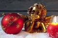 Christmas bulb burning candle golden putto on pile of snow