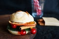 Christmas burger on a wooden board next to candycanes on a dark background