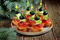 Christmas canape on skewer from bread baguette with toast cheese, sausage, tomato, cucumber and olives. Traditional snack for the