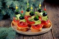 Christmas canape on skewer from bread baguette with toast cheese, sausage, tomato, cucumber and olives. Traditional snack for the