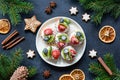 Christmas canape tartlets or cupcakes with cream and berries on white plate. Winter holidays food.
