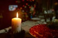 Christmas candle on dark background before the fir-tree.