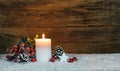 Christmas candle decoration with pine cone, fir tree, red berries, star and red christmas baubles Royalty Free Stock Photo